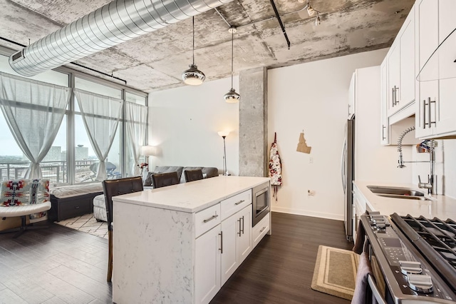 50 E 16th St Unit 1111, Chicago, IL 60616 - kitchen featuring appliances with stainless steel finishes, a sink, dark wood-style flooring, white cabinets, and pendant lighting