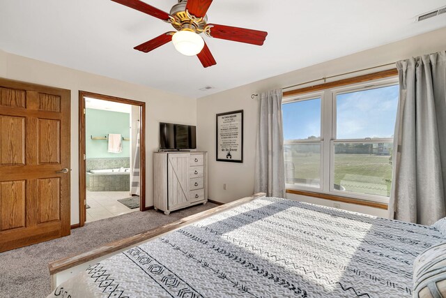 carpeted bedroom with ensuite bathroom, ceiling fan, and baseboards