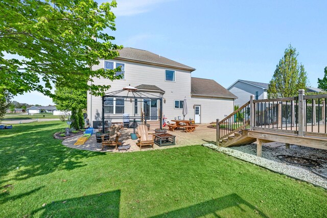 back of house with an outdoor fire pit, a gazebo, a patio, a wooden deck, and a yard