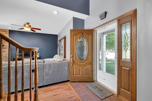 entryway with stairs, a ceiling fan, lofted ceiling, and wood finished floors