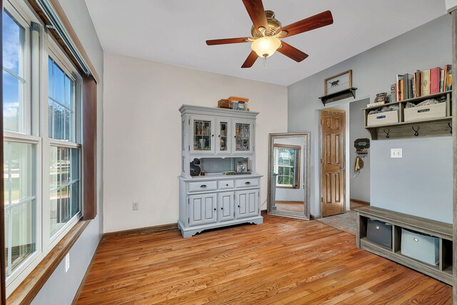 unfurnished dining area featuring light wood-style flooring and a ceiling fan
