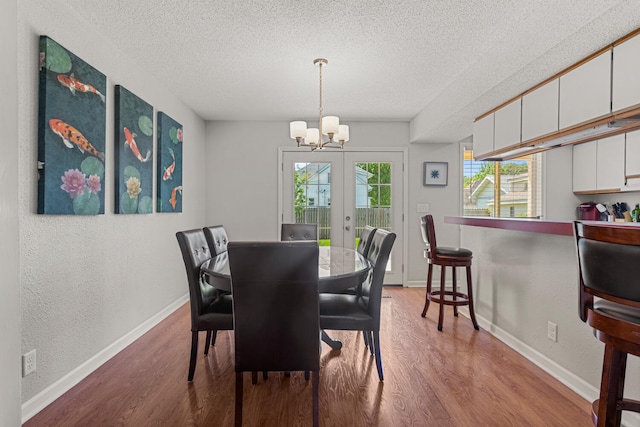 913 W Eads St, Urbana, IL 61801 - dining room featuring a chandelier, wood finished floors, a textured ceiling, french doors, and baseboards