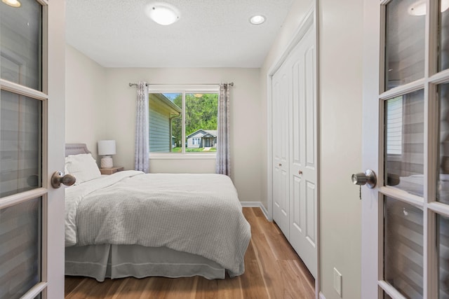 913 W Eads St, Urbana, IL 61801 - bedroom with wood finished floors, a closet, recessed lighting, a textured ceiling, and baseboards