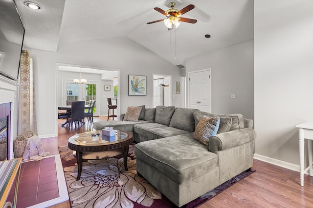 913 W Eads St, Urbana, IL 61801 - living room with wood finished floors, vaulted ceiling, a ceiling fan, baseboards, and a chandelier