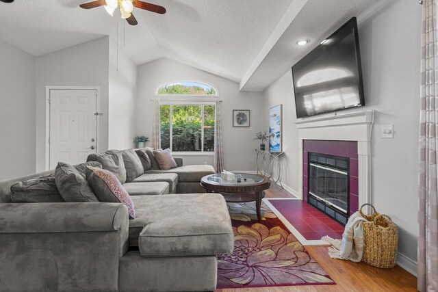 913 W Eads St, Urbana, IL 61801 - living room with vaulted ceiling, a ceiling fan, a fireplace, wood finished floors, and a textured ceiling