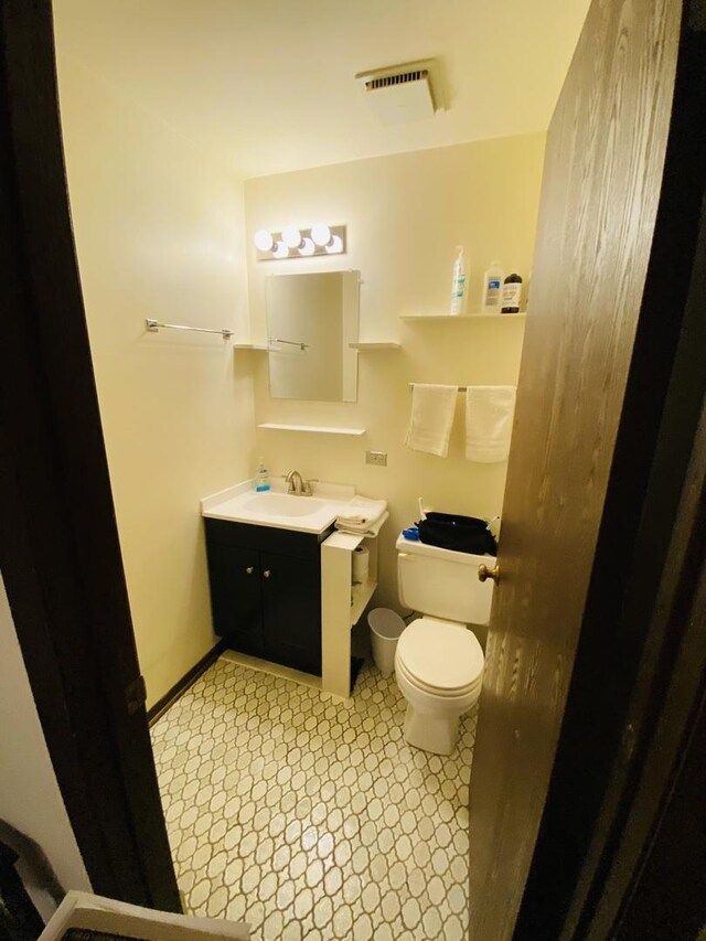 half bathroom featuring toilet and vanity