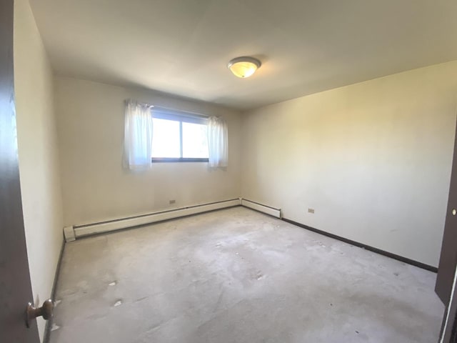 14643 Lamon Ave Unit 2A, Midlothian, IL 60445 - empty room with unfinished concrete flooring, a baseboard heating unit, and baseboards