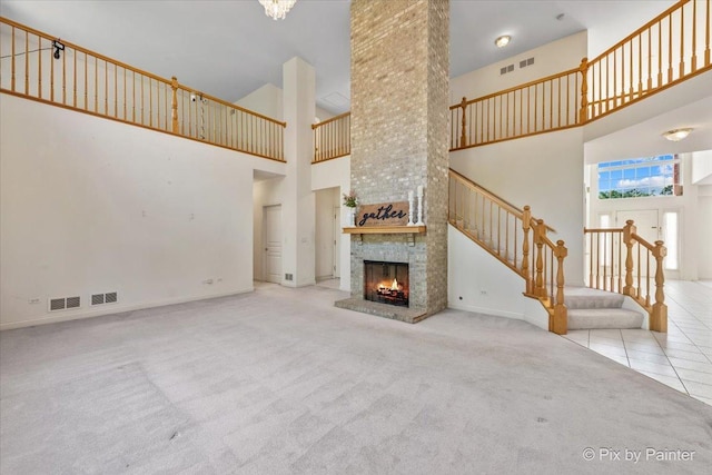 405 Lela Ln, Bartlett, IL 60103 - unfurnished living room featuring a towering ceiling, carpet flooring, stairway, a fireplace, and baseboards
