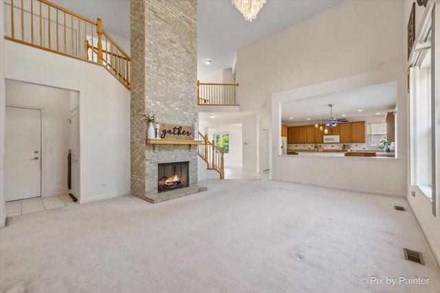 405 Lela Ln, Bartlett, IL 60103 - unfurnished living room featuring light colored carpet, a chandelier, a towering ceiling, a brick fireplace, and recessed lighting