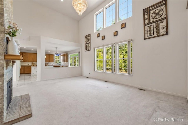 405 Lela Ln, Bartlett, IL 60103 - unfurnished living room with a fireplace, a high ceiling, light colored carpet, a chandelier, and baseboards