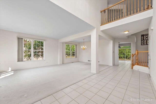 405 Lela Ln, Bartlett, IL 60103 - unfurnished living room featuring a chandelier, carpet floors, baseboards, and tile patterned floors