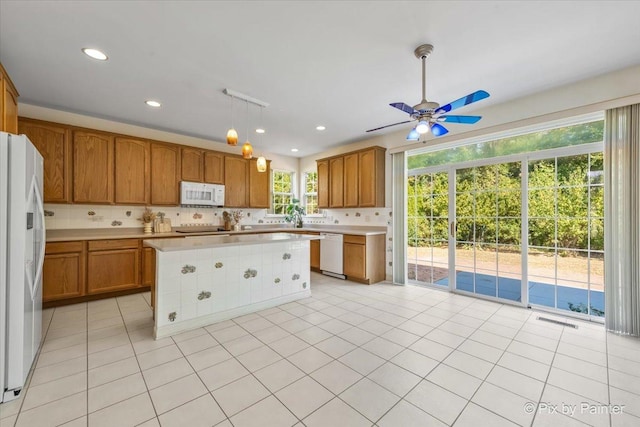 405 Lela Ln, Bartlett, IL 60103 - kitchen featuring white appliances, light countertops, ceiling fan, decorative backsplash, and brown cabinets