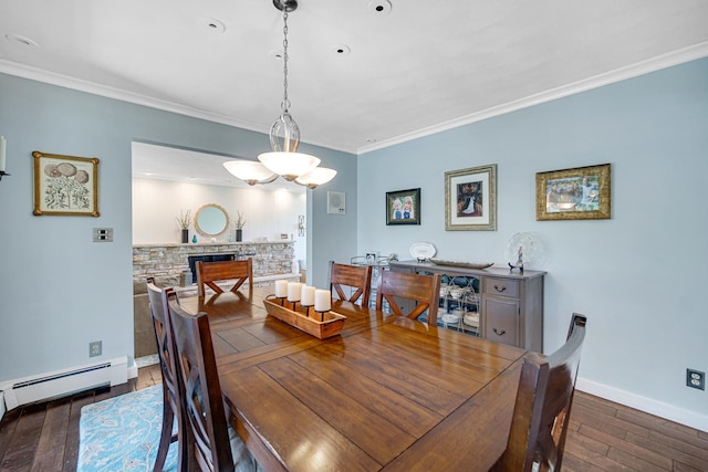 dining space with wood finished floors, baseboards, ornamental molding, a baseboard heating unit, and a stone fireplace