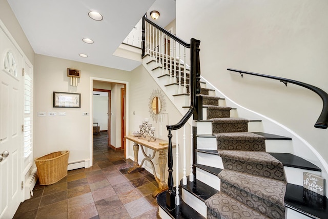 staircase with stone tile flooring, recessed lighting, baseboards, and baseboard heating
