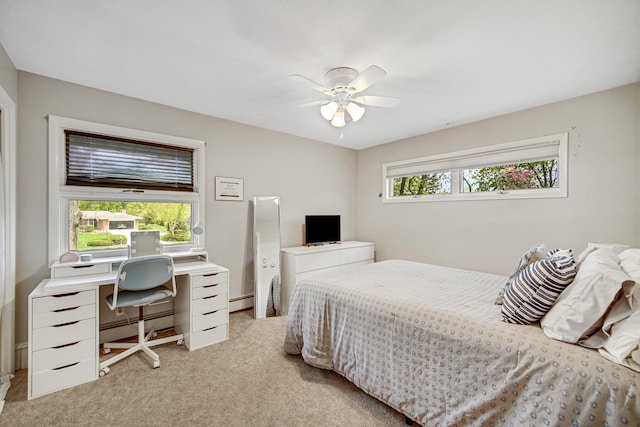 bedroom with light carpet, a baseboard radiator, a baseboard heating unit, and a desk