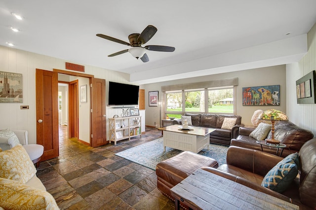 living area featuring stone tile flooring, ceiling fan, baseboards, and recessed lighting