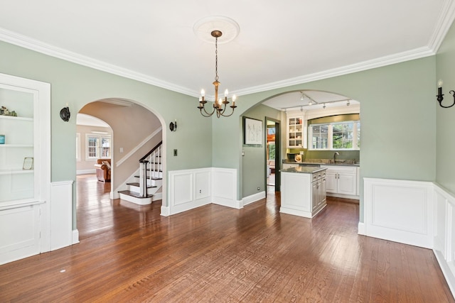 2141 Evans Rd, Flossmoor, IL 60422 - unfurnished dining area featuring arched walkways, a chandelier, a wainscoted wall, dark wood-type flooring, and stairs