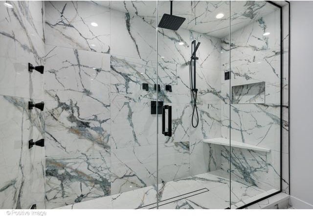 bathroom with a marble finish shower