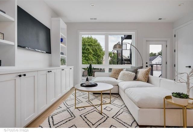 living area with visible vents and light wood-style floors