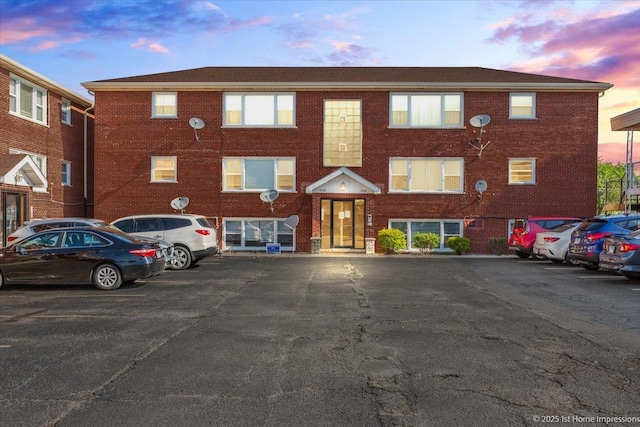 property at dusk with uncovered parking