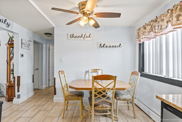dining room featuring a baseboard radiator, a ceiling fan, light wood-style floors, and baseboards