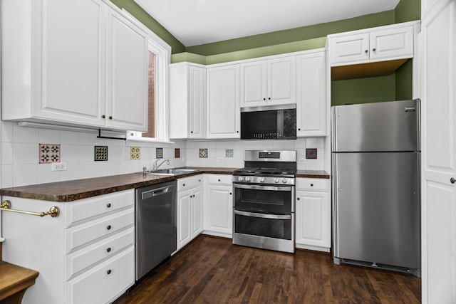 827 Madison St, Evanston, IL 60202 - kitchen with appliances with stainless steel finishes, dark countertops, white cabinets, dark wood-style floors, and tasteful backsplash