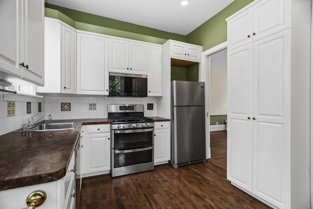 827 Madison St, Evanston, IL 60202 - kitchen featuring appliances with stainless steel finishes, a sink, dark countertops, white cabinets, and dark wood-type flooring