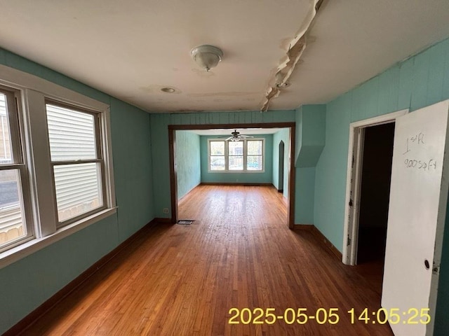 unfurnished room with ceiling fan, baseboards, and wood finished floors