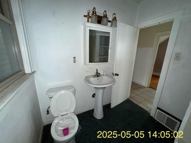 bathroom featuring toilet, tile patterned floors, and visible vents