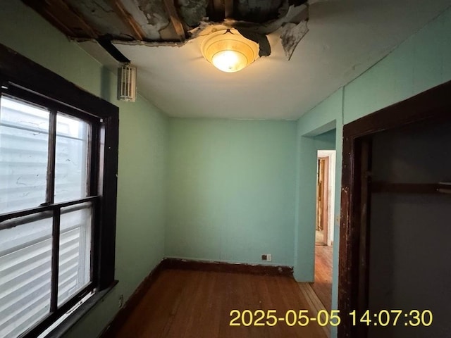 unfurnished bedroom featuring baseboards and dark wood-type flooring