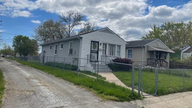 15015 Winchester Ave, Harvey, IL 60426 - view of front of home with a fenced front yard, a gate, and a chimney