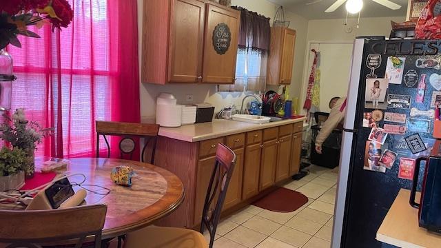 15015 Winchester Ave, Harvey, IL 60426 - kitchen with freestanding refrigerator, light countertops, light tile patterned floors, and a ceiling fan