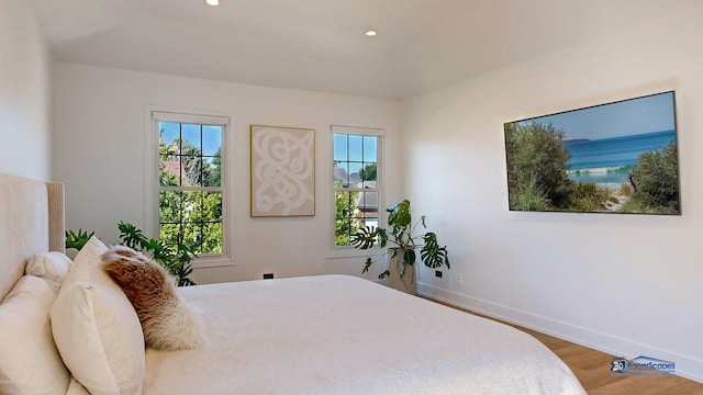 bedroom with multiple windows, wood finished floors, baseboards, and recessed lighting