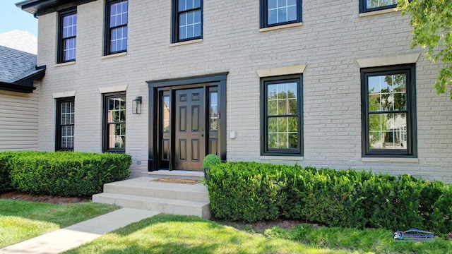 doorway to property featuring brick siding