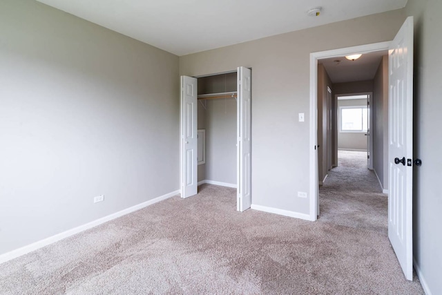 unfurnished bedroom featuring carpet, baseboards, and a closet