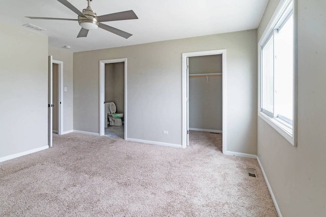 unfurnished bedroom featuring carpet flooring, a walk in closet, baseboards, and a closet