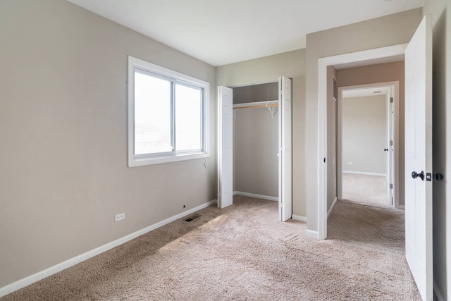 unfurnished bedroom featuring carpet flooring, baseboards, and a closet