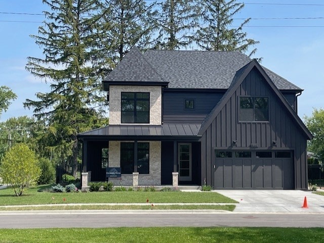 62 Miller Rd, Lake Zurich, IL 60047 - view of front of house featuring driveway, board and batten siding, a porch, an attached garage, and a front lawn