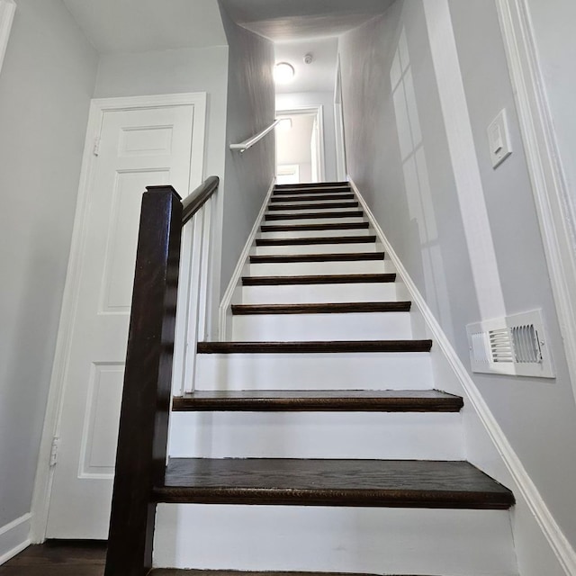 stairway with wood finished floors and baseboards