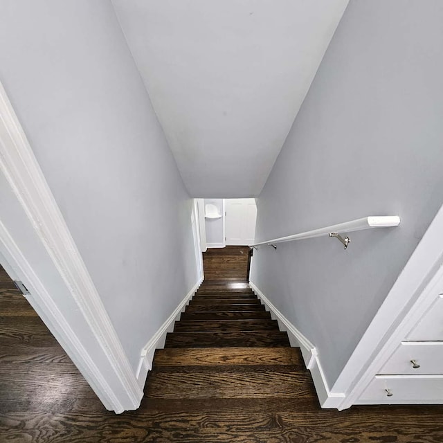 stairs featuring wood finished floors and baseboards