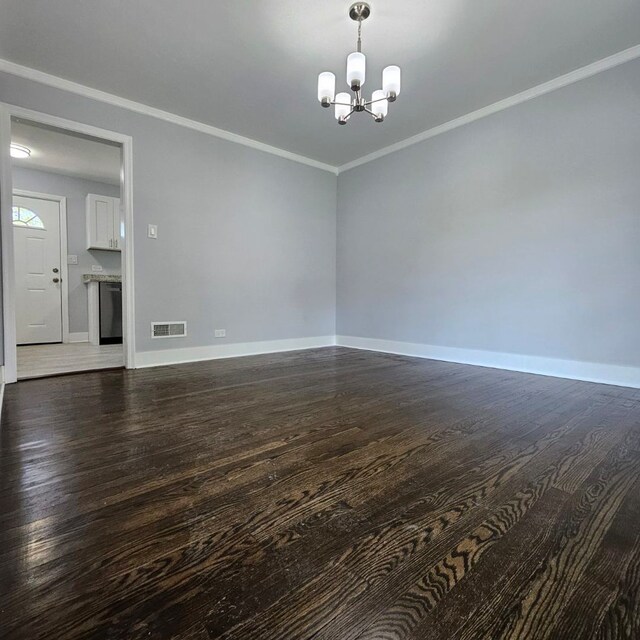 unfurnished room with a chandelier, wood finished floors, baseboards, and crown molding