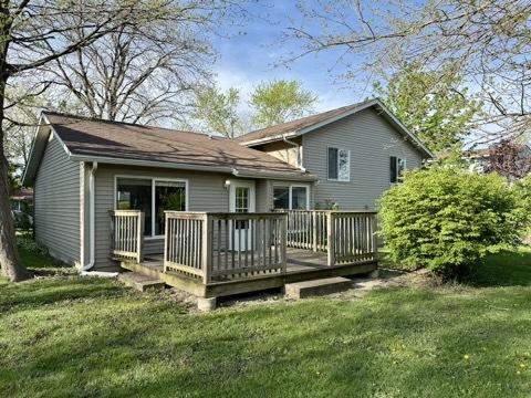rear view of property featuring a wooden deck and a yard