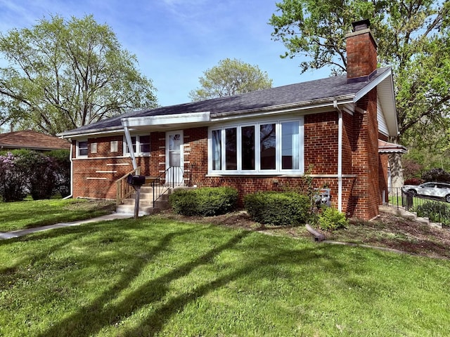 view of front of property with brick siding, a front lawn, and a chimney