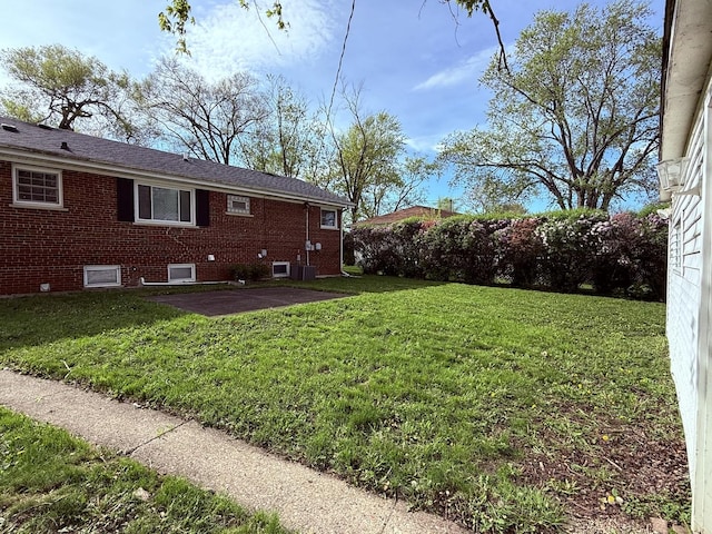 view of green lawn featuring a patio area