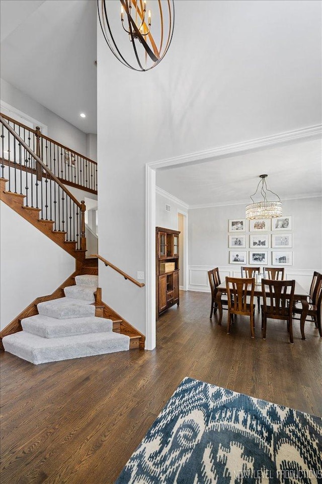 living room with a chandelier, wood finished floors, stairway, crown molding, and recessed lighting