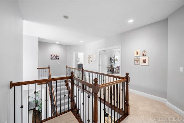 hallway with an upstairs landing, carpet flooring, baseboards, and recessed lighting