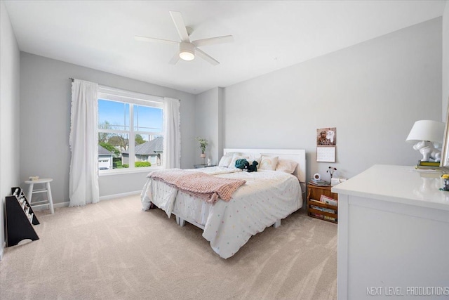 bedroom with light colored carpet, a ceiling fan, and baseboards