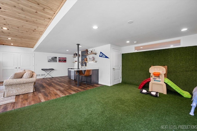 recreation room featuring a dry bar, recessed lighting, baseboards, and wood finished floors