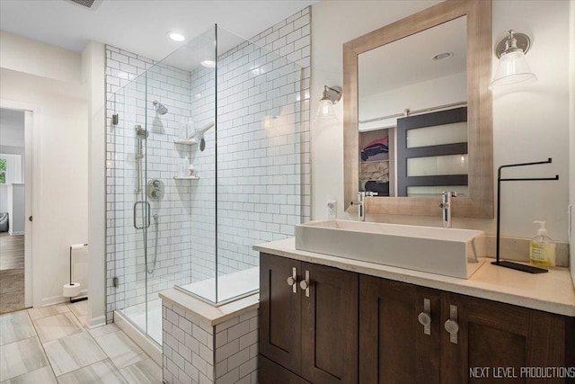 ensuite bathroom with a shower stall, vanity, recessed lighting, and tile patterned floors