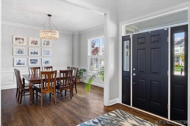 foyer entrance with a chandelier, dark wood-style floors, crown molding, and baseboards